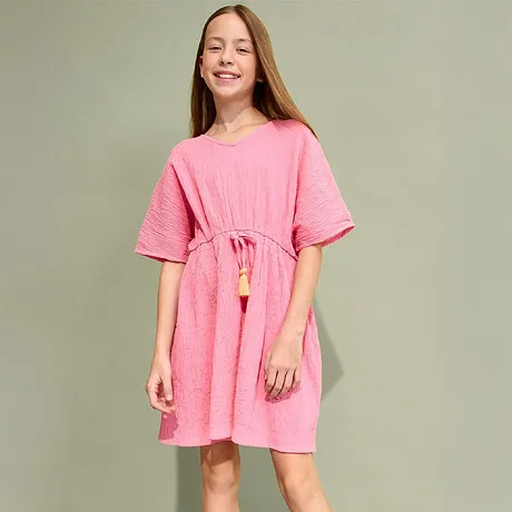 Abito estivo rosa con maniche corte, coulisse in vita e nappe. Abbinato a sandali dorati.