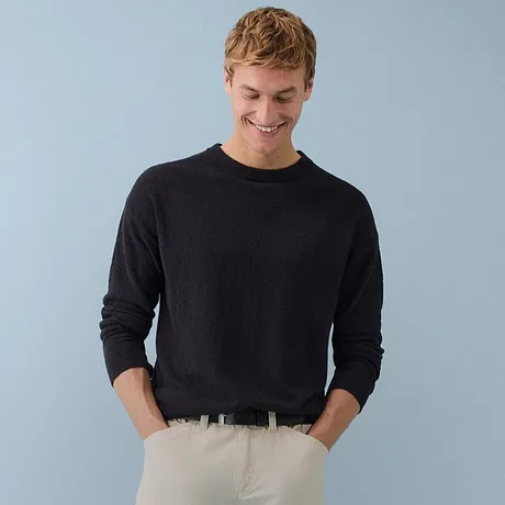 Elegante maglione a collo alto nero abbinato a pantaloni in velluto a coste verde oliva.