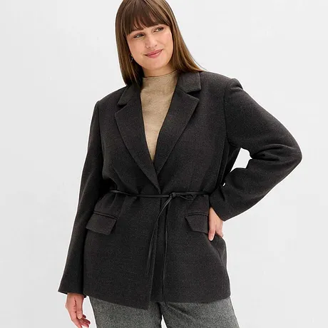 Blazer grigio con cintura, abbinato a dolcevita beige. 