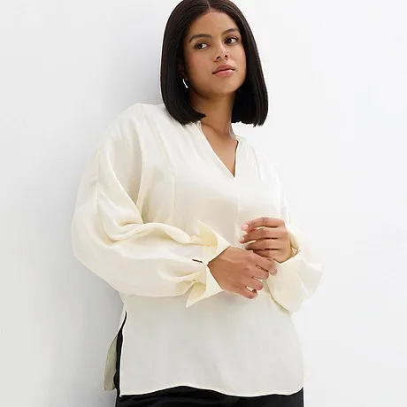 Elegante camicetta bianca con scollo a V e maniche ampie.