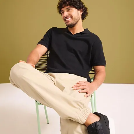 T-shirt nera e pantaloni chiari in cotone.