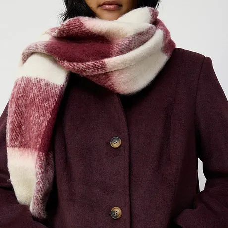  Elegante cappotto bordeaux abbinato a una soffice sciarpa rossa e bianca. 
