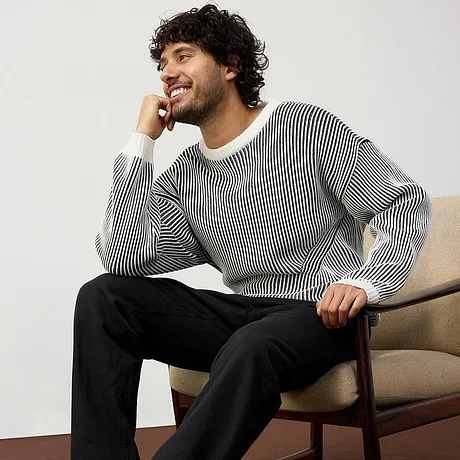 Maglione a righe abbinato a pantaloni neri. 