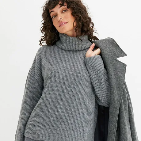 Maglione a collo alto grigio e cappotto abbinato.