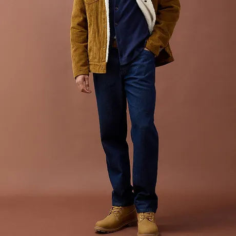 Jeans blu, giacca di velluto a coste giallo senape e robusti stivali beige.