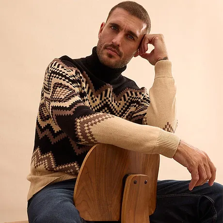 Maglione caldo con motivo geometrico e jeans blu.