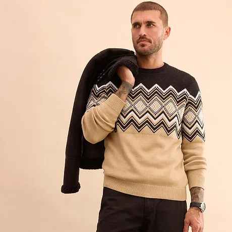 Maglione lavorato a maglia con motivo decorativo nei colori beige e nero.