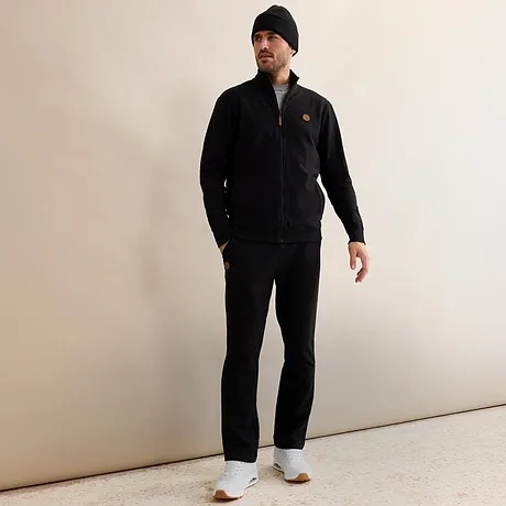 Tuta da jogging nera con cappuccio e scarpe da ginnastica bianche.