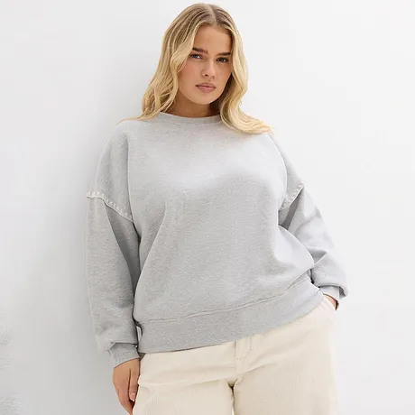 Felpa grigia abbinata a pantaloni chiari.