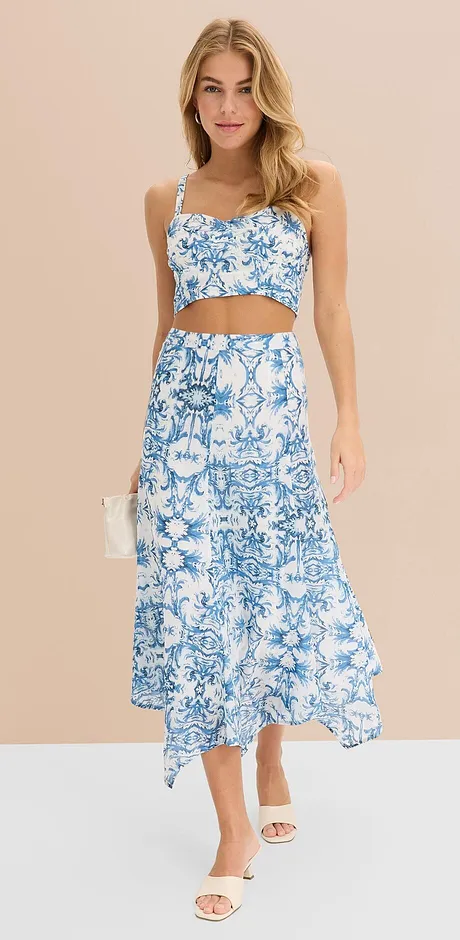 Completo estivo a due pezzi con motivo floreale blu e bianco: crop-top con spalline sottili e gonna lunga con orlo asimmetrico. 