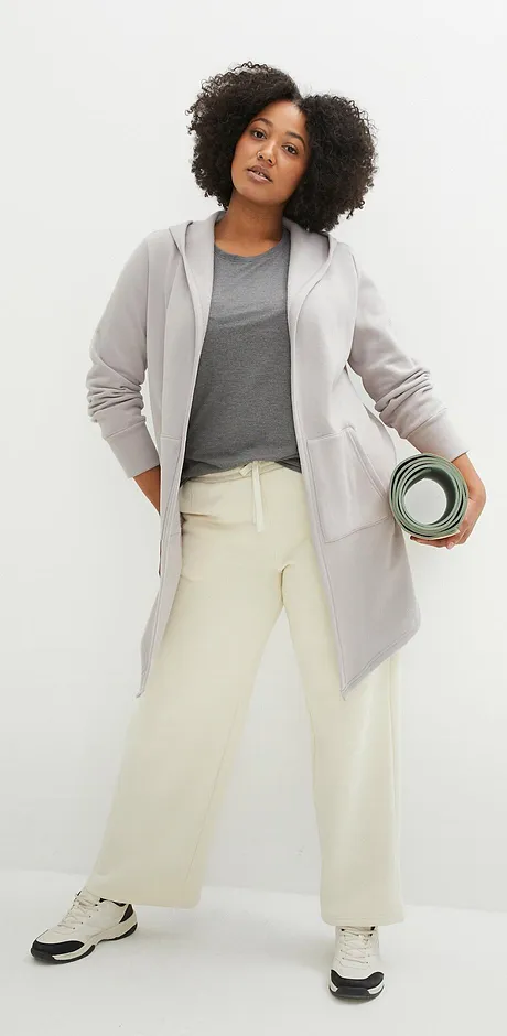 Felpa, t-shirt e pantaloni color crema per un look sportivo.