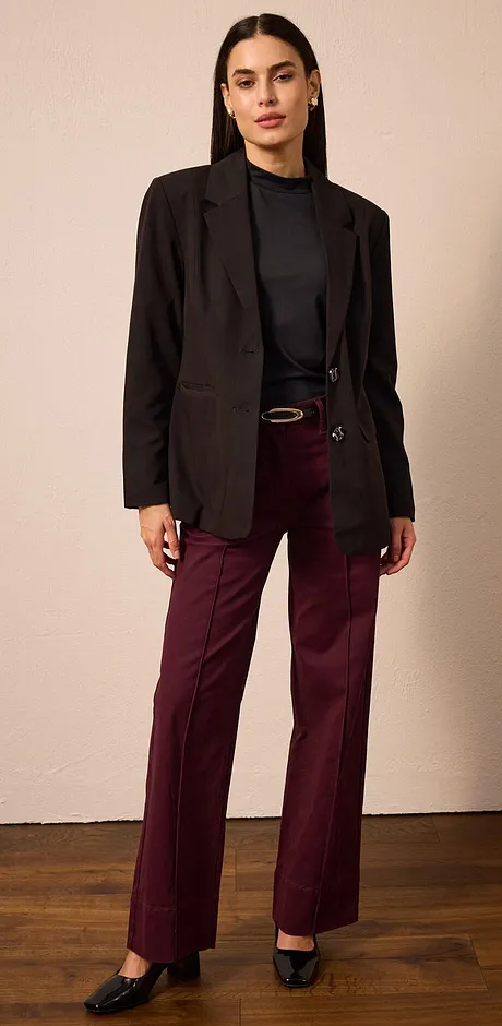 Blazer nero, dolcevita scuro e pantaloni bordeaux. 