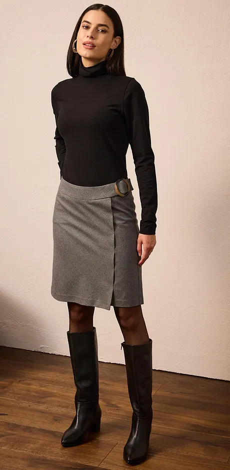 Look elegante con dolcevita nero, gonna grigia e stivali neri alti. 