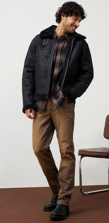 Jeans marroni casual, camicia a quadri e stivali di pelle neri.