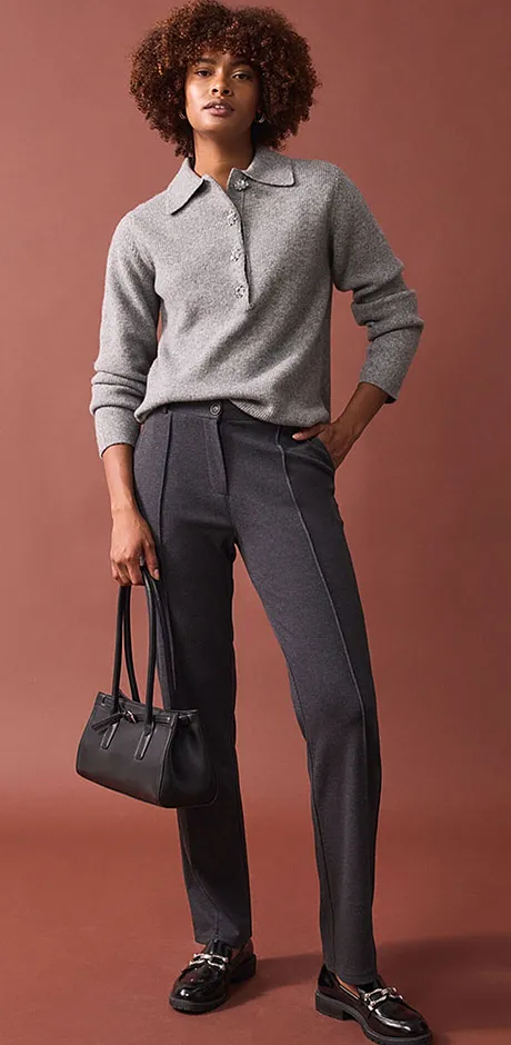 Elegante maglione grigio abbinato a pantaloni eleganti e mocassini neri.