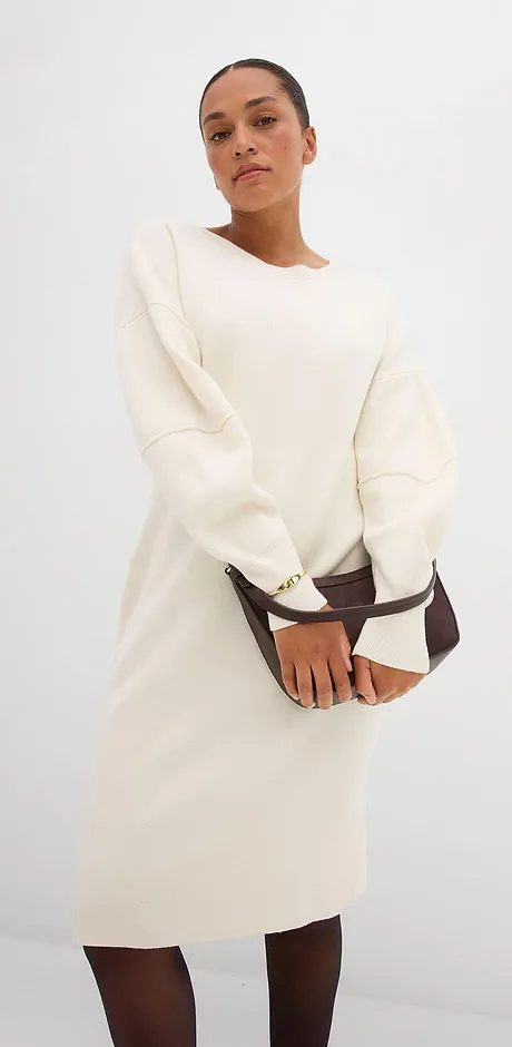 Un abito color crema a maniche lunghe con scollo rotondo.
