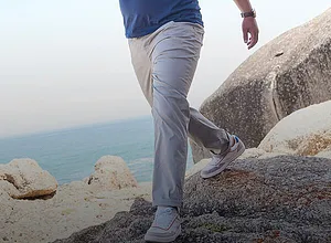 Pantaloni in stoffa chiara con sneakers bianche.