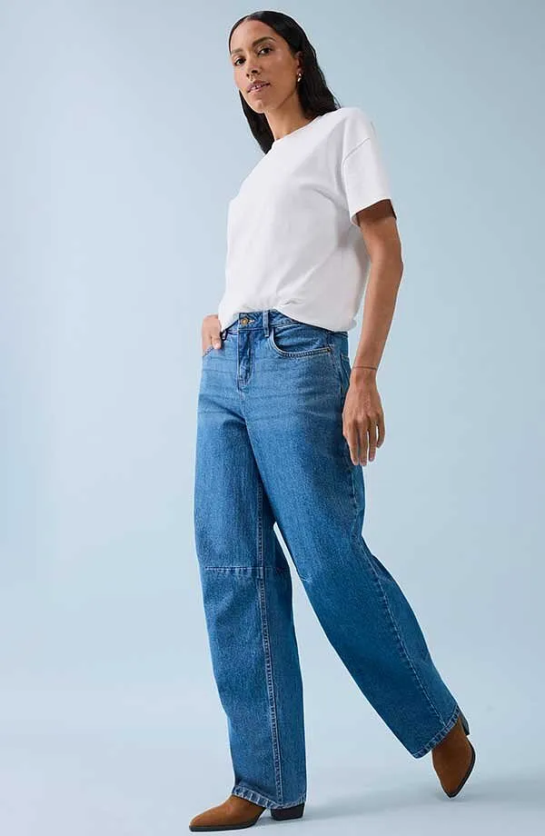 Classica t-shirt bianca abbinata a jeans ampi e scarpe marroni.