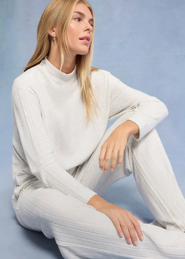 Elegante maglione bianco lavorato a maglia con collo alto, perfetto da abbinare a pantaloni bianchi coordinati.