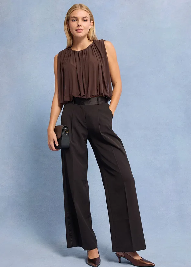  Top marrone senza maniche e pantaloni larghi scuri. 