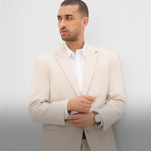 Elegante blazer color crema abbinato a una camicia bianca.