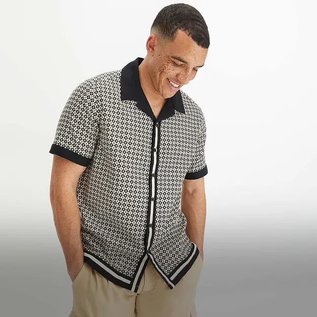 Camicia a maniche corte in fantasia, con colletto e bordi a contrasto.