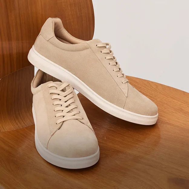 Sneaker beige in pelle scamosciata con suola bianca.