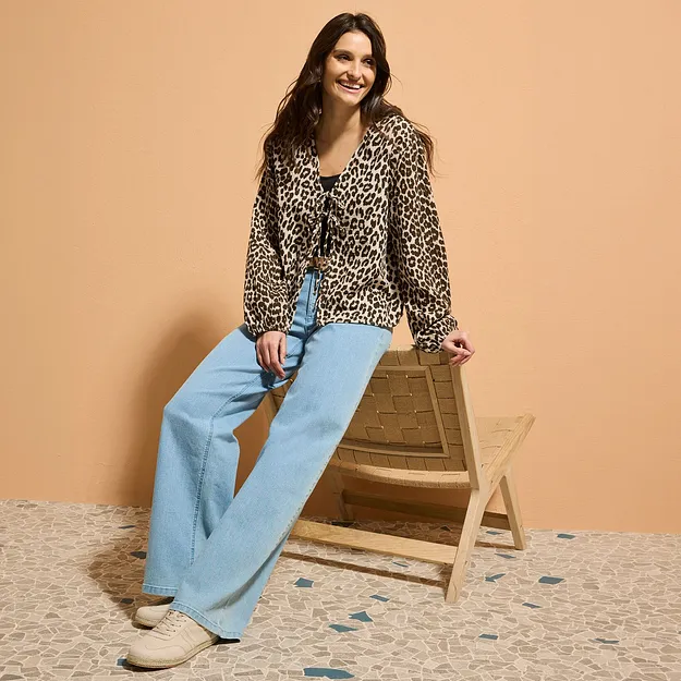 Una camicetta con stampa leopardata abbinata a jeans a zampa di elefante azzurri.