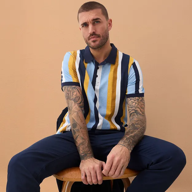 Polo a righe con colletto blu scuro, abbinata a pantaloni blu scuro