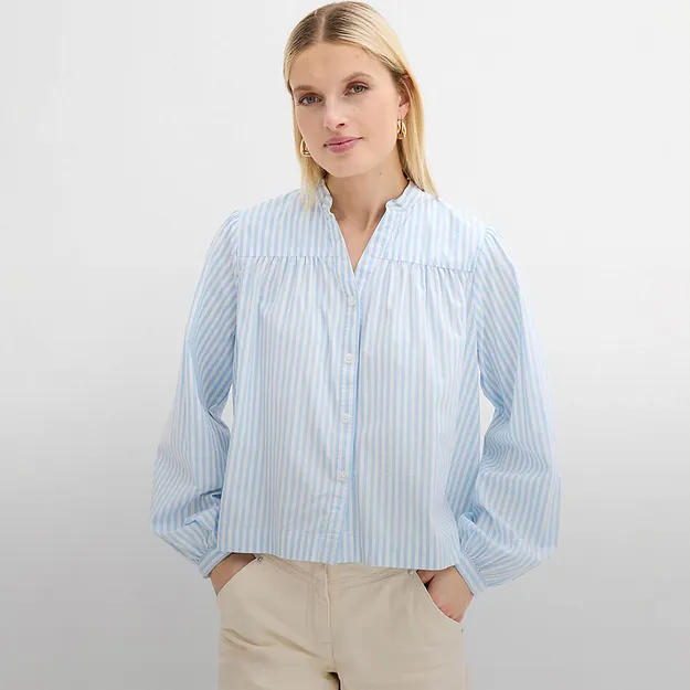 Camicia azzurra a righe bianche con scollo a V.