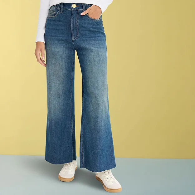 Jeans larghi con maglia bianca e sneaker chiare.