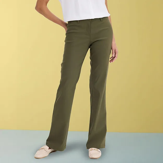 Eleganti pantaloni verde oliva abbinati a un top bianco e scarpe beige.