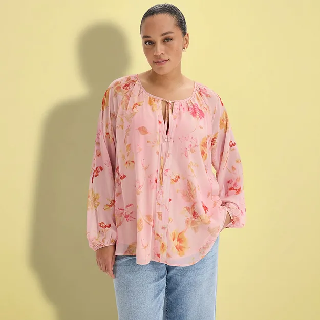 Una blusa rosa a fiori e dei jeans larghi.