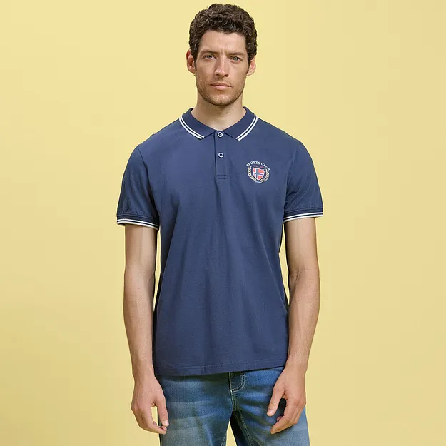Una polo blu dal taglio sportivo con logo abbinata a un paio di shorts di jeans dal look casual.
