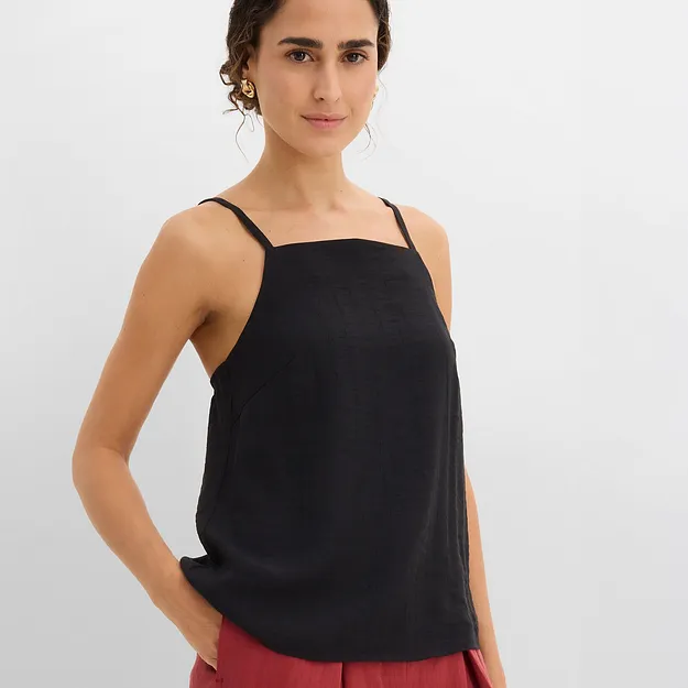 Un top nero abbinato a pantaloni larghi rossi per un look casual.
