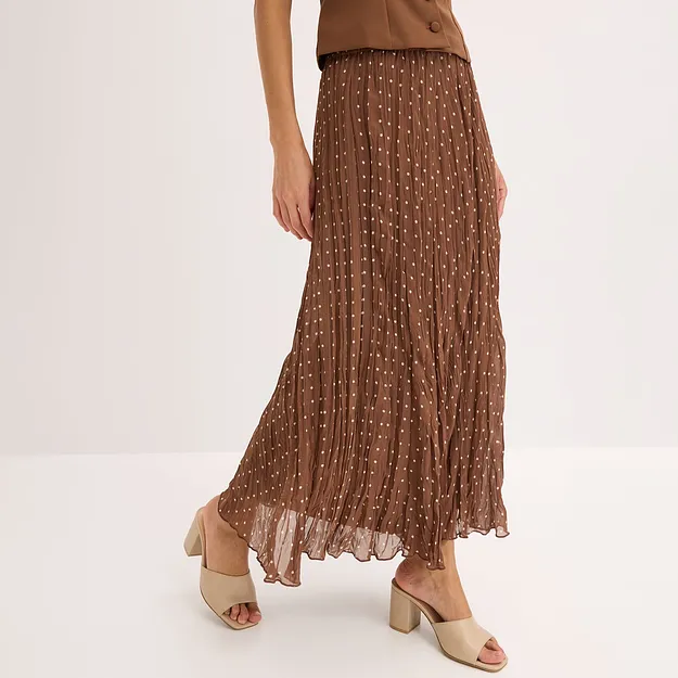 Gonna plissettata marrone a pois bianchi, top marrone e mules con tacco beige.