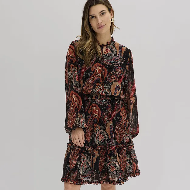Indossa un abito fluido con un motivo paisley colorato e dettagli a balze.