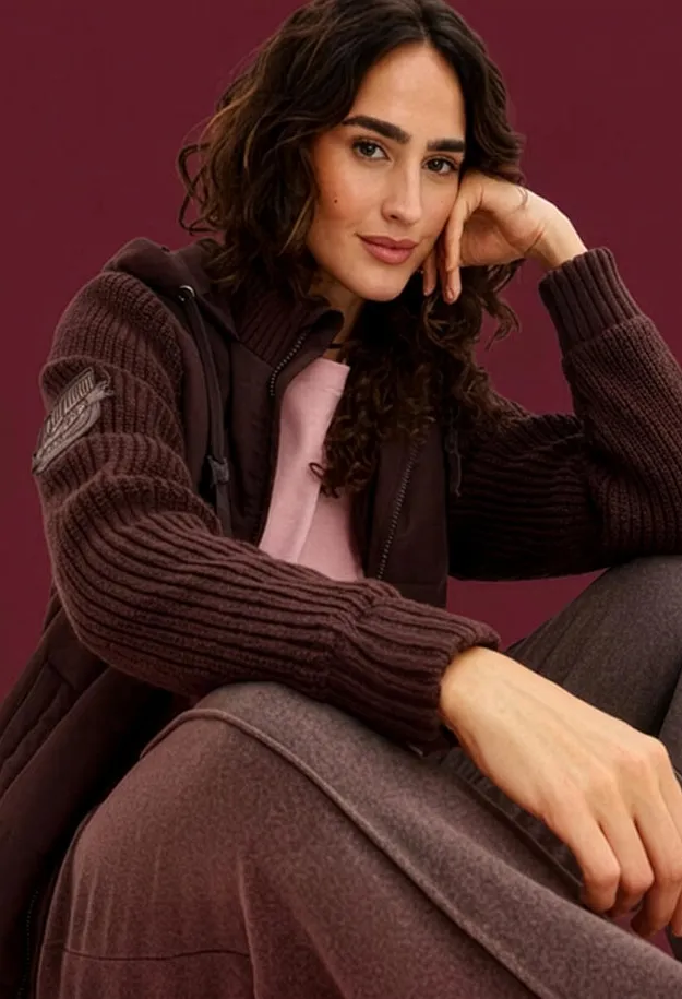Cardigan pesante con maniche lavorate a maglia, top rosa e pantaloni abbinati nei toni del marrone.