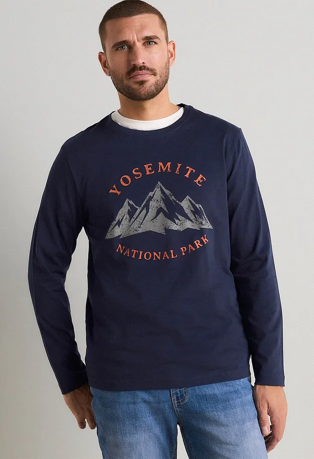 Maglietta a maniche lunghe blu scuro con stampa Yosemite e jeans per un look casual.
