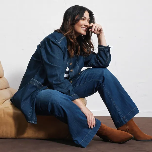 Un look completo in denim di grande stile: giacca di jeans, pantaloni larghi ed eleganti stivaletti marroni.