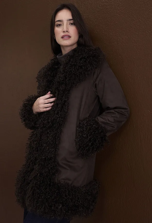 Cappotto marrone con collo e polsini morbidi, abbinato a un maglione a collo alto.