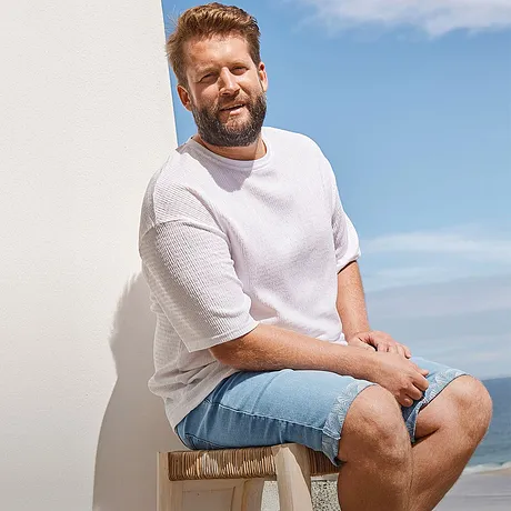  Look estivo casual: t-shirt bianca e pantaloncini corti in jeans azzurri per una giornata in spiaggia. 