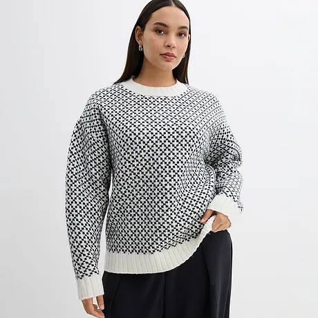 Maglione lavorato a maglia con motivo bianco e nero e maniche lunghe.