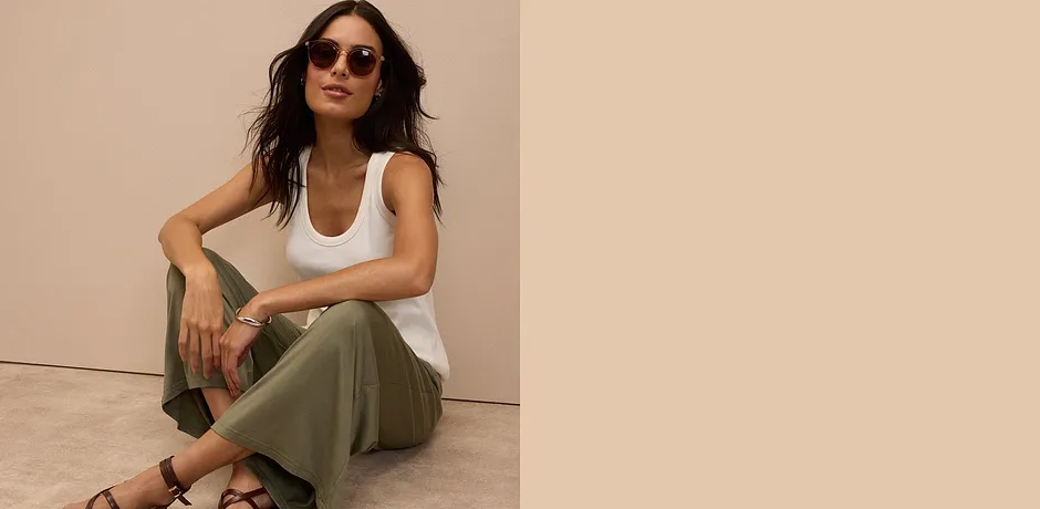 Canotta bianca, pantaloni verde oliva e sandali marroni - un look estivo casual con occhiali da sole. 