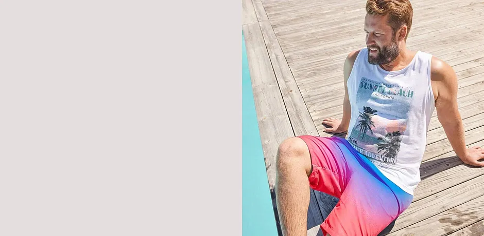 Canotta bianca e pantaloncini da bagno colorati in rosa e blu per piscina e mare.