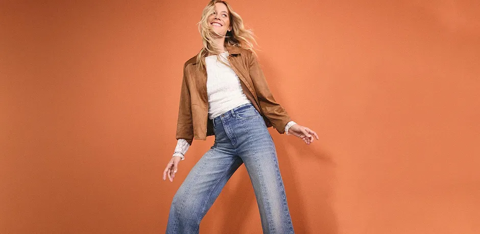 Look casual: giacca di similpelle marrone, top bianco e jeans ampi per uno stile rilassato.
