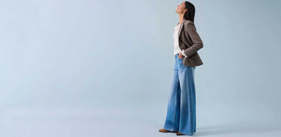 Jeans ampi, top chiaro e blazer beige per uno stile rilassato.