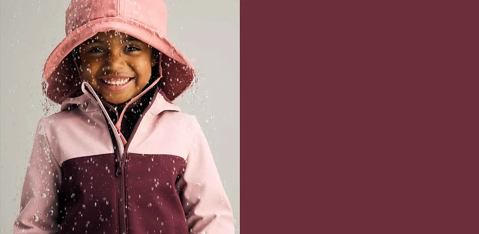 Giacca antipioggia in rosa e bordeaux abbinata a un cappello da pioggia. Perfetto per il maltempo.