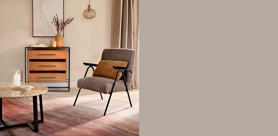 Comoda poltrona con tessuto grigio e braccioli in legno, in armonia con gli interni caldi.