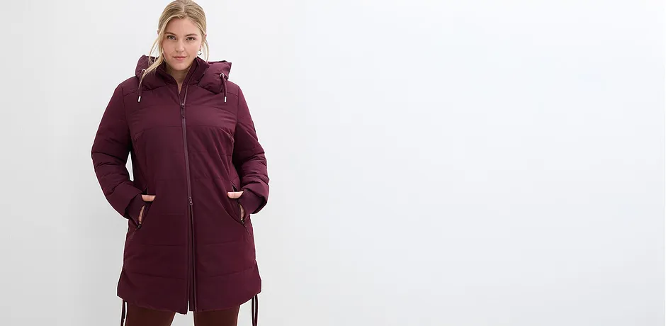 Una giacca invernale lunga e calda in rosso scuro con cappuccio e zip.
